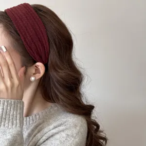 Gros plan d'un bandeau en maille bordeaux élégant avec une texture torsadée sur un modèle