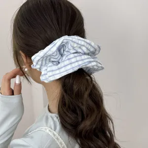 Detail view of blue and white checkered scrunchie hair tie used for low ponytail