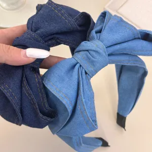 Detailweergave van de textuur en stiksels van denim strik-haarbanden in twee kleuren.