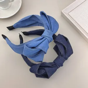 Gedetailleerd overzicht van twee stijlvolle denim haarbanden met strik in blauwe tinten.