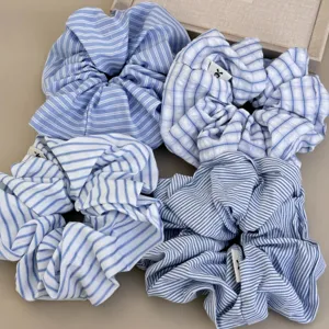 Detailed view of four assorted blue and white striped and checkered fabric scrunchies