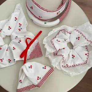Set of white lace hair accessories with sweet cherry prints and red gingham accents.