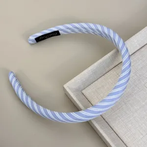 Detailed view of a light blue and white striped fabric headband with texture details