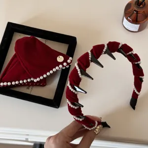 Close-up detail of vintage red velvet headband with elegant pearls and comb teeth