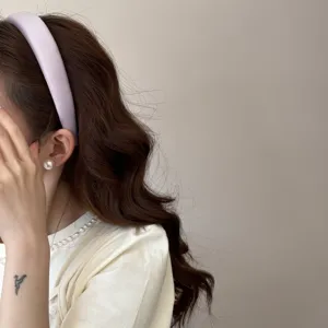 Primer plano de una modelo con una diadema de esponja color crema para un estilo dulce y chic.
