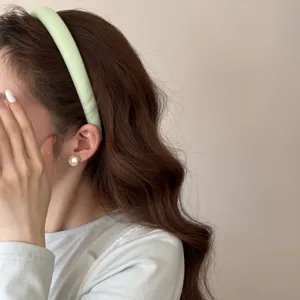 Gros plan d'un serre-tête éponge rembourré vert clair sur un mannequin femme élégant