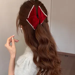 Elegant red velvet bow hair clip with white pearl trim for autumn and winter festive look