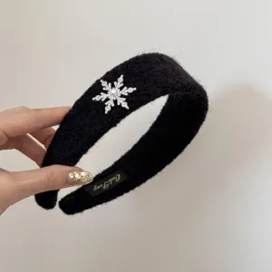 Detailed view of a premium plush black headband with an elegant rhinestone snowflake ornament