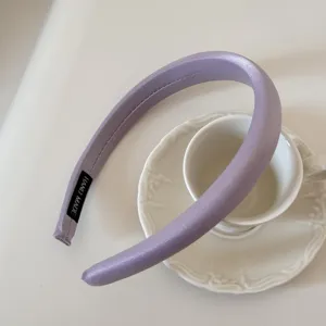 Primer plano de una diadema acolchada color lavanda sobre una taza de té de cerámica