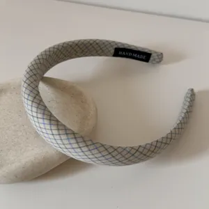 Détail d'un serre-tête à carreaux argyle colorés avec étiquette fait main