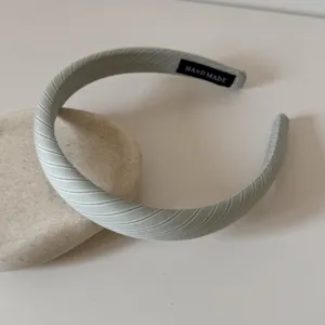 Vue détaillée du tissu rayé et de l'étiquette faite main de ce large serre-tête chic