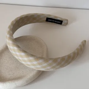 Gros plan d'un serre-tête rembourré à carreaux jaunes avec étiquette Hand Made