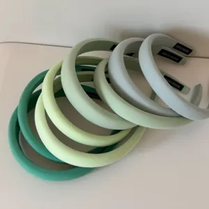 Détail de serre-têtes en tissu rembourré déclinés en plusieurs nuances de vert
