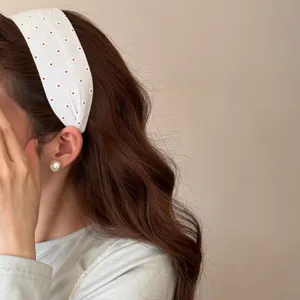 Elegante fascia larga in tessuto floreale bianco con orecchino di perla su modella.