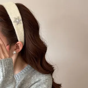 Elegant cream plush headband decorated with a sparkling rhinestone snowflake charm