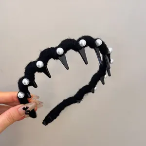 Detail of black knitted wavy headband with pearls and anti-slip teeth