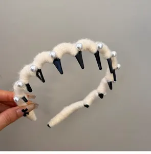 Close-up detail of cream white wool yarn headband with elegant pearls and wave design