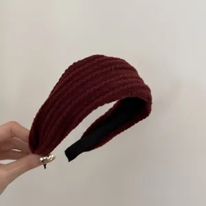 Détail d'un serre-tête en tricot bordeaux avec une texture torsadée de style rétro