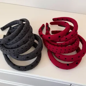 Detailed view of padded headbands in red and grey colors featuring a black heart pattern