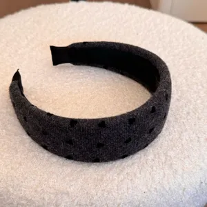 Vue détaillée de la texture velours doux et des motifs cœurs noirs sur le bandeau gris