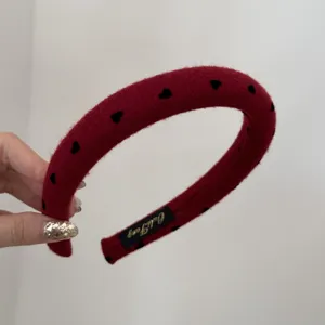 Detailed macro shot of red padded headband with black heart pattern and high-top design
