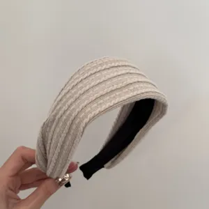 Vue détaillée d'un bandeau rétro beige en maille torsadée avec une finition douce