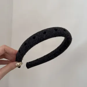 Close-up view of a grey padded headband featuring cute heart cutouts and a soft wool-like texture