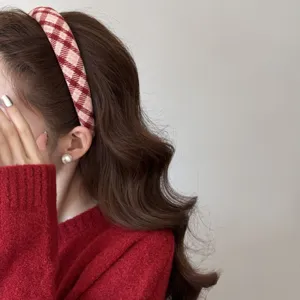 Gros plan latéral d'un serre-tête à carreaux rouges et blancs sur cheveux ondulés