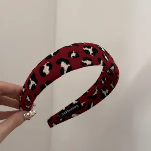 Détail d'un serre-tête rouge à motif léopard montrant l'étiquette HANDMADE interne