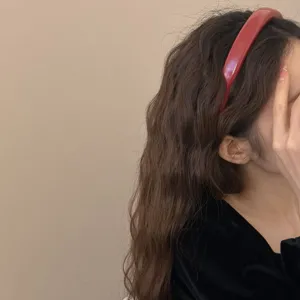 Elegant red patent leather headband for women featuring a stylish high gloss finish.