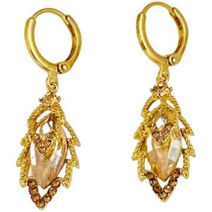 Gros plan d'élégantes boucles d'oreilles feuilles dorées avec strass et cristaux brillants.