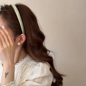 Serre-tête élégant de style coréen à pois vert sauge sur cheveux bruns ondulés