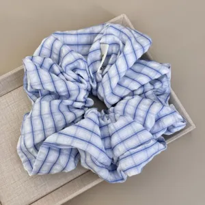 Detailed view of the soft blue and white striped fabric texture of a large hair scrunchie