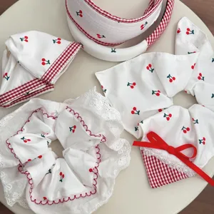 Cute white lace scrunchie and headband set with red cherry and gingham patterns.