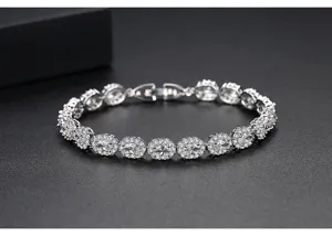 Primer plano de pulsera plateada con eslabones ovalados de circonitas micro-pavé.