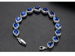 Primer plano de una elegante pulsera con circonitas AAA azules en forma de pera y plata