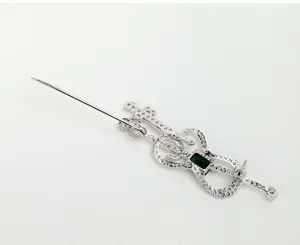 Back view of a vintage violin brooch with micro-inlaid white cubic zirconia and green stone