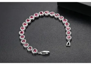 Vista detallada de pulsera con forma de corazón y piedras de circonita roja engastadas en pavé