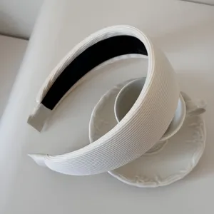 Detailed close-up of a white ribbed padded headband with thick sponge and black lining
