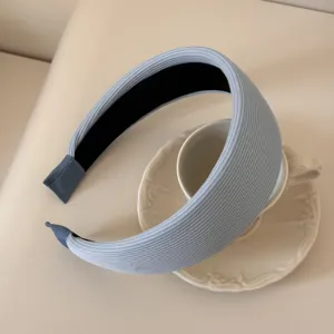 Detailed close-up of light blue ribbed fabric sponge headband on a white teacup.