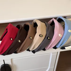 Gros plan de bandeaux larges en velours de diverses couleurs avec petits logos de cheval