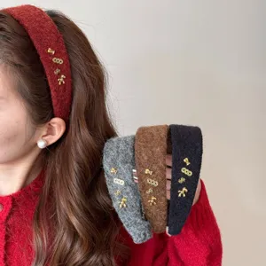 Serre-tête en peluche avec breloques porte-bonheur en rouge, gris et noir.