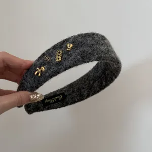 Détail de serre-tête en peluche grise avec breloques dorées et étiquette OuliFang