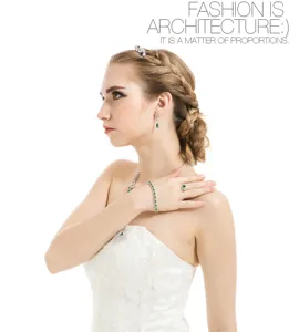 Detalle de un conjunto de joyas verdes en forma de pera con modelo en vestido de novia