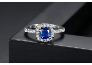 Vista detallada de un anillo plateado con una pietra cuadrada de color azul brillante