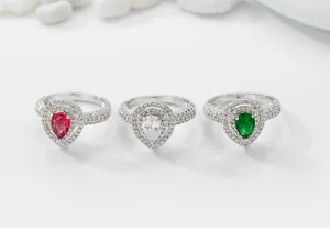 Vista detallada de elegantes anillos en forma de pera con circonitas rojas, claras y verdes.