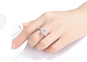 Elegante anillo de plata con circonita cúbica cuadrada y engaste de halo en la mano