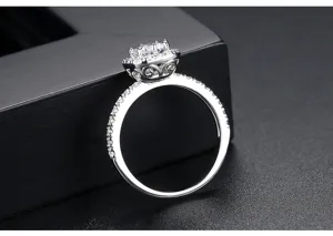 Anillo elegante de circonita plateada con un engaste halo detallado y ornamentado