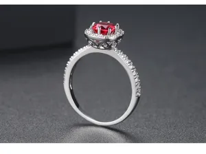 Primer plano de un anillo plateado con una vibrante piedra preciosa de circón rojo.