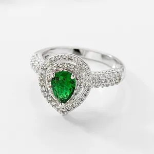 Elegante anillo de circonita verde esmeralda en forma de pera con halo brillante en plata